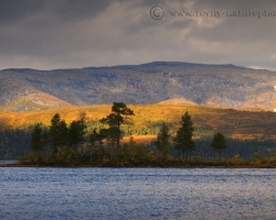 Sun is playing and chasing shadows over the silvery surface of a large inland lake.