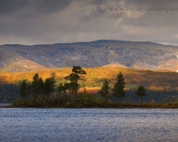 Sun is playing and chasing shadows over the silvery surface of a large inland lake.