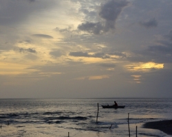 Tribal fisherman waiting in the waning light their catch.