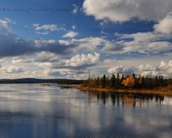 Performance among clouds shadows water and colors of the great river in a nature reserve Kaituma Fjällurskog in Sweden.